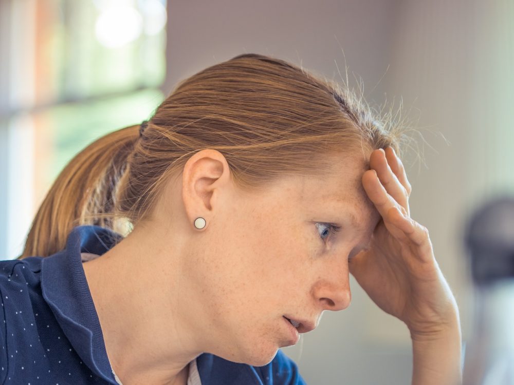 Woman looking stressed with her hand on her forehead
