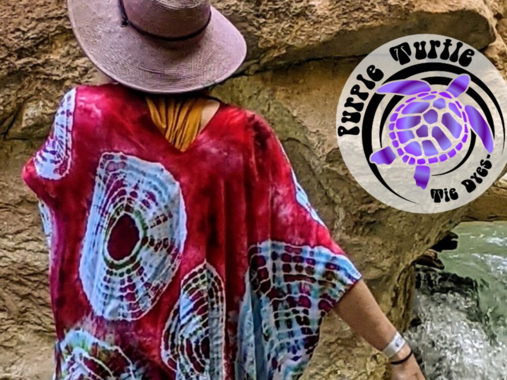 Purple Turtle Tie Dyes with an image of a purple turtle and a woman wearing a tie dye caftan in red and white and a purple hat