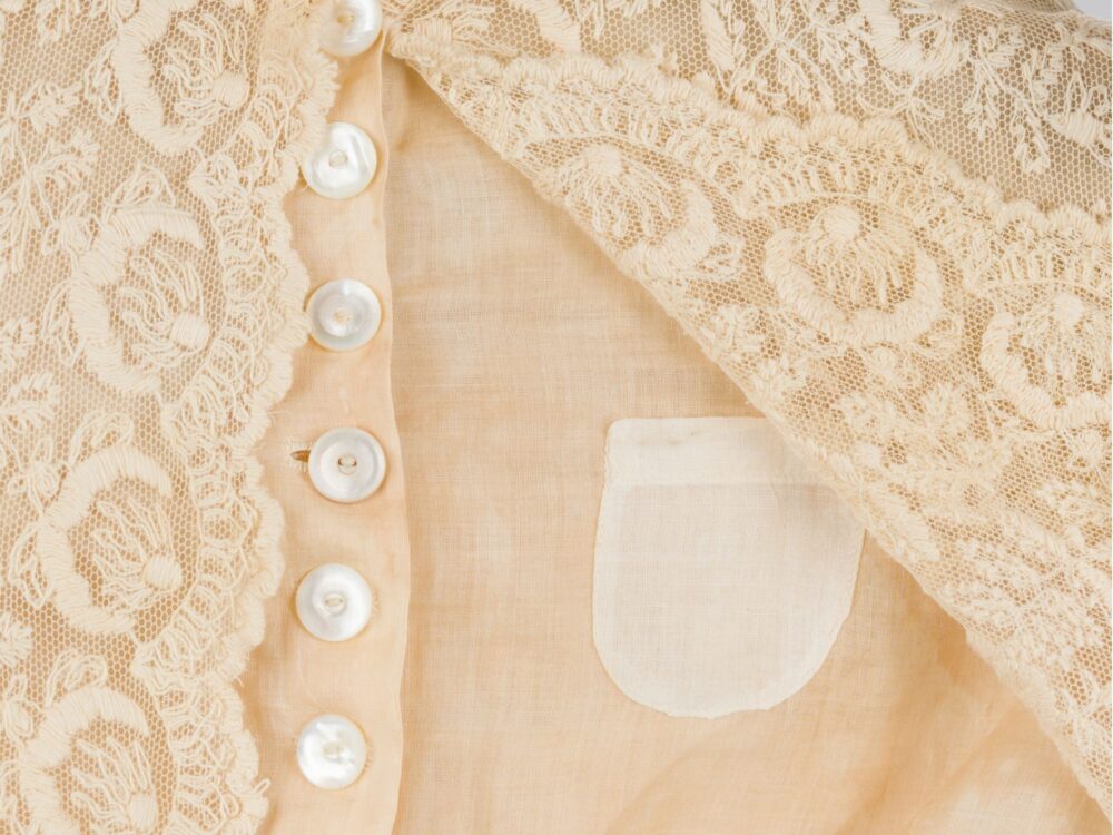 A detail image of a lace blouse with a hidden pocket.