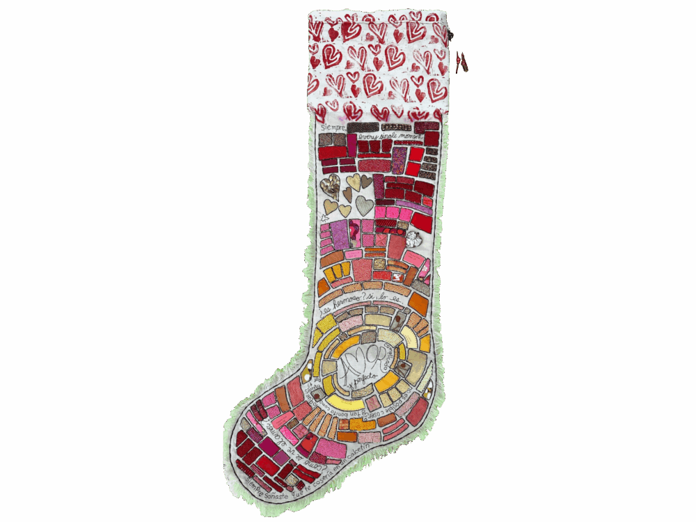 A heavily beaded stocking in warm tones. The top of the stocking has a white fabric with printed red hearts.