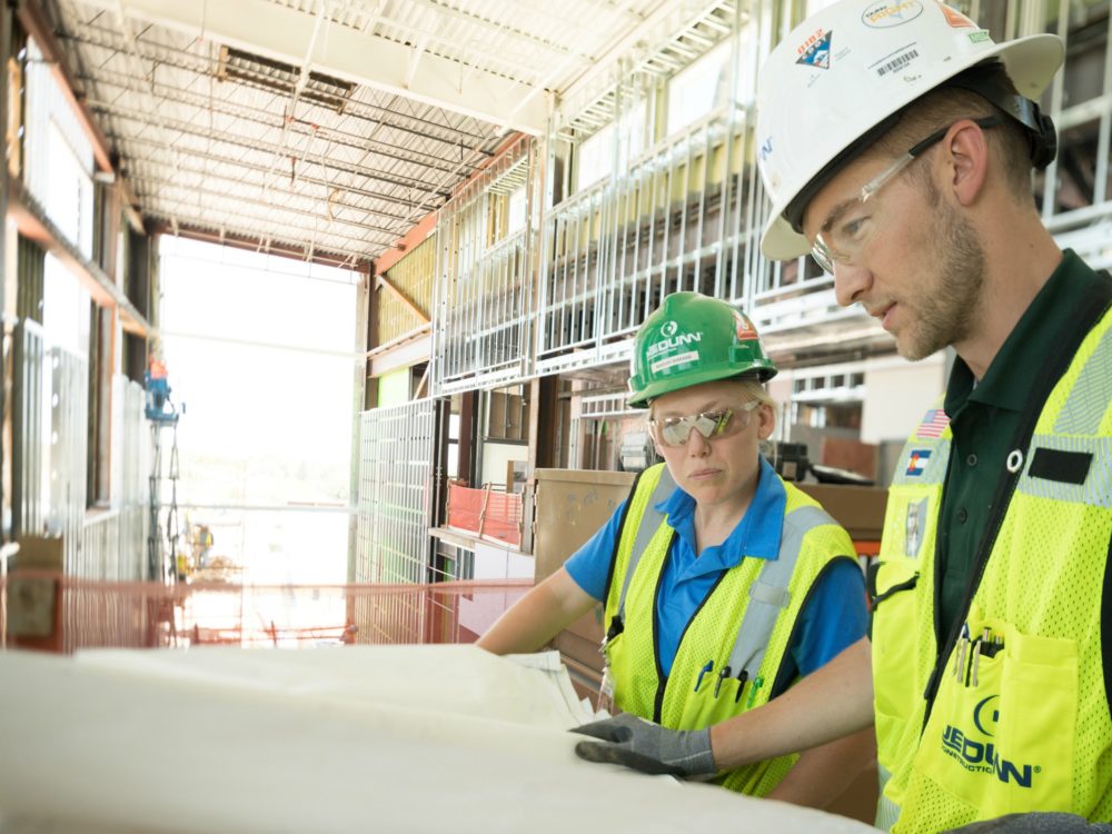 2 CM interns reviewing plans on jobsite