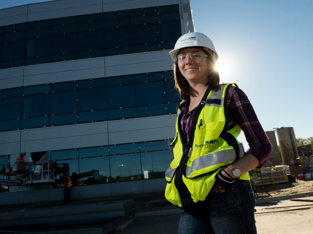 Construction Management alumna on jobsite in a hardhat.