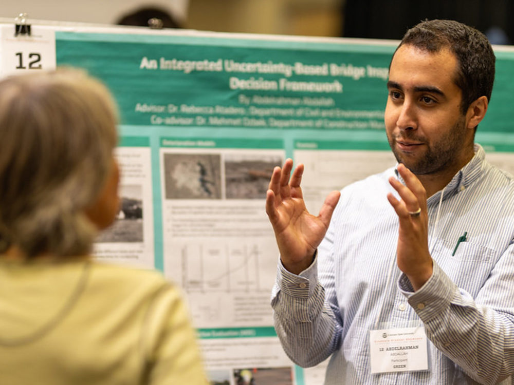 graduate student presenting a poster