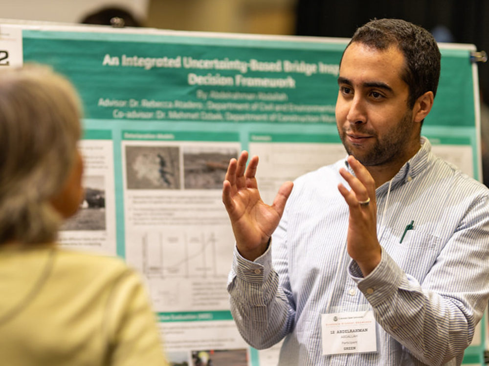 graduate student presenting a poster