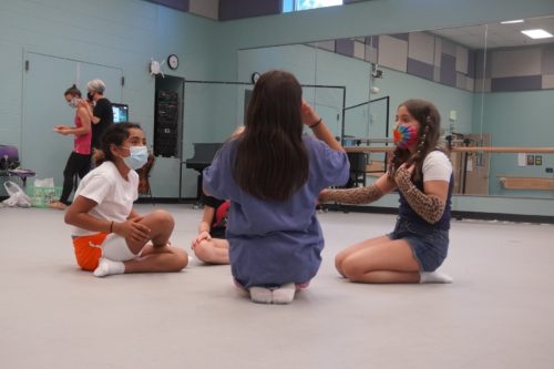 Four students on the floor in a dance studio