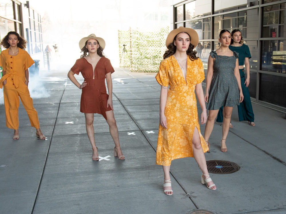 five models wearing dresses and pantsuits
