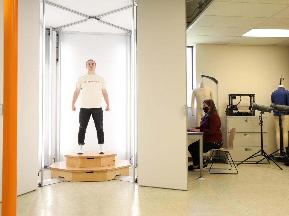 a fit model stands in a 3D body scanner in a research lab to collect data as a part of earning an M.S. in Design and Merchandising