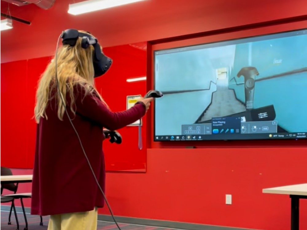 a graduate student explores interior design renderings with virtual reality goggles