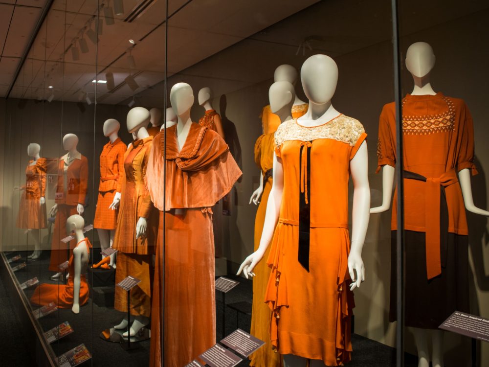 A series of mannequins dressed in orange n the blackwell gallery