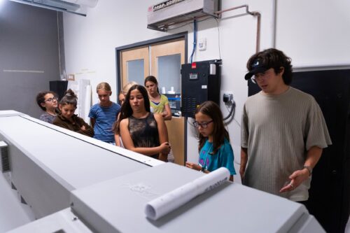 Students watch the digital textile printer
