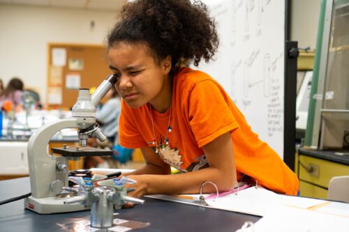a student looks through the microscope in the textile science lab