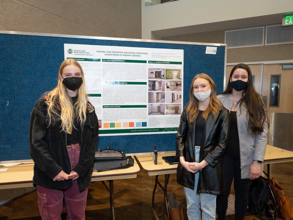 Three SPACE Lab student researchers stand in front of their poster at CHHS Research day