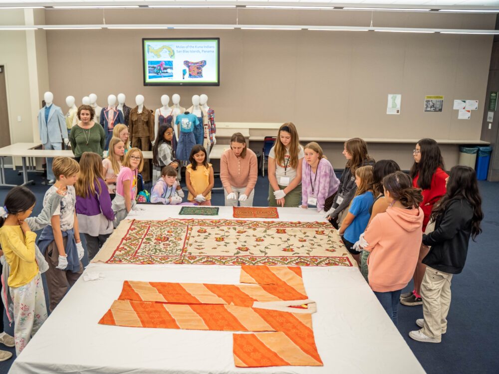 students gather around historic kimonos at the Avenir Museum of Design and Merchandising.