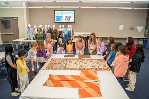 students gather around historic kimonos at the Avenir Museum of Design and Merchandising.