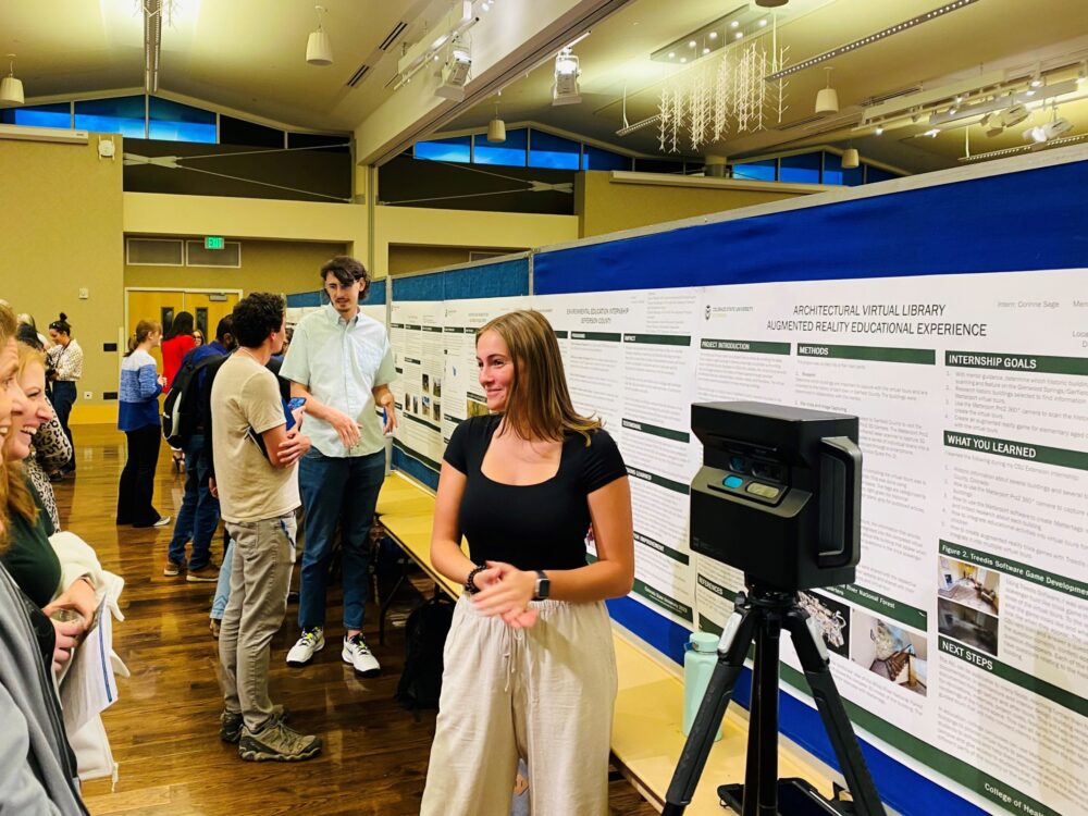 Corinne Sage presenting research poster with the 3D matterport camera