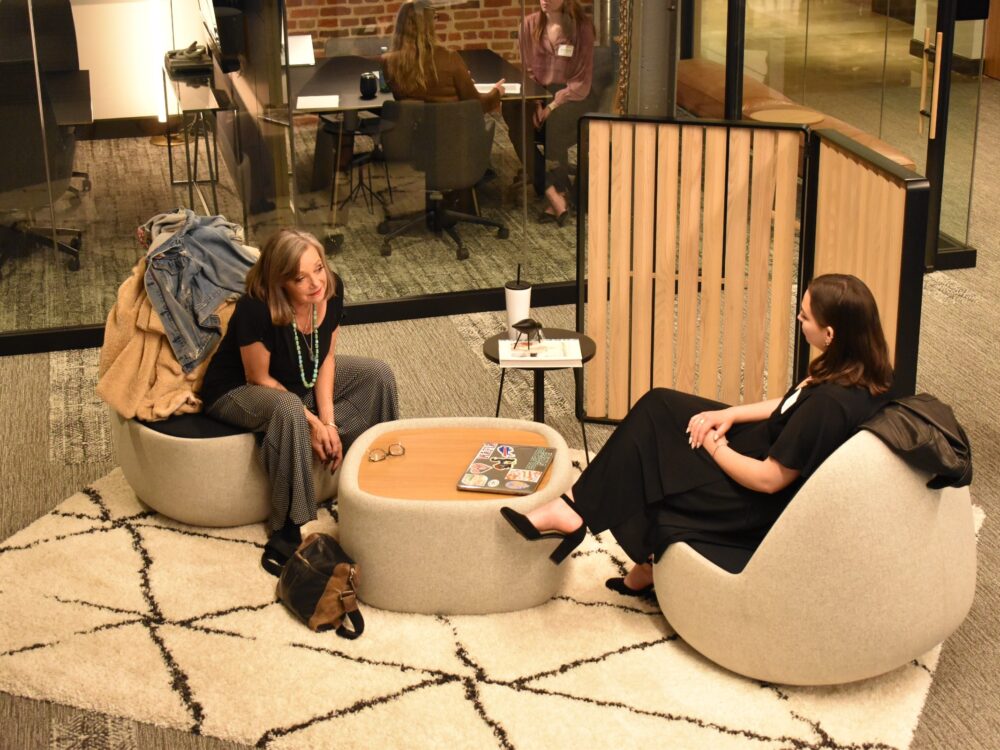 a student interviews with a design professional in a space showcasing interior products.