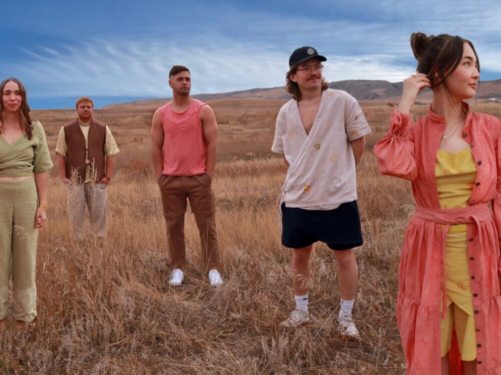 one of the student collections a woman in a green outfit with wrap top, a man in pants and brown vest, a man in brown pants and pink shirt, a man in shorts and wrapped eco-print top, a woman in wrapped yellow pants and top with pink jacket, collection by Vallerie Bortolutti