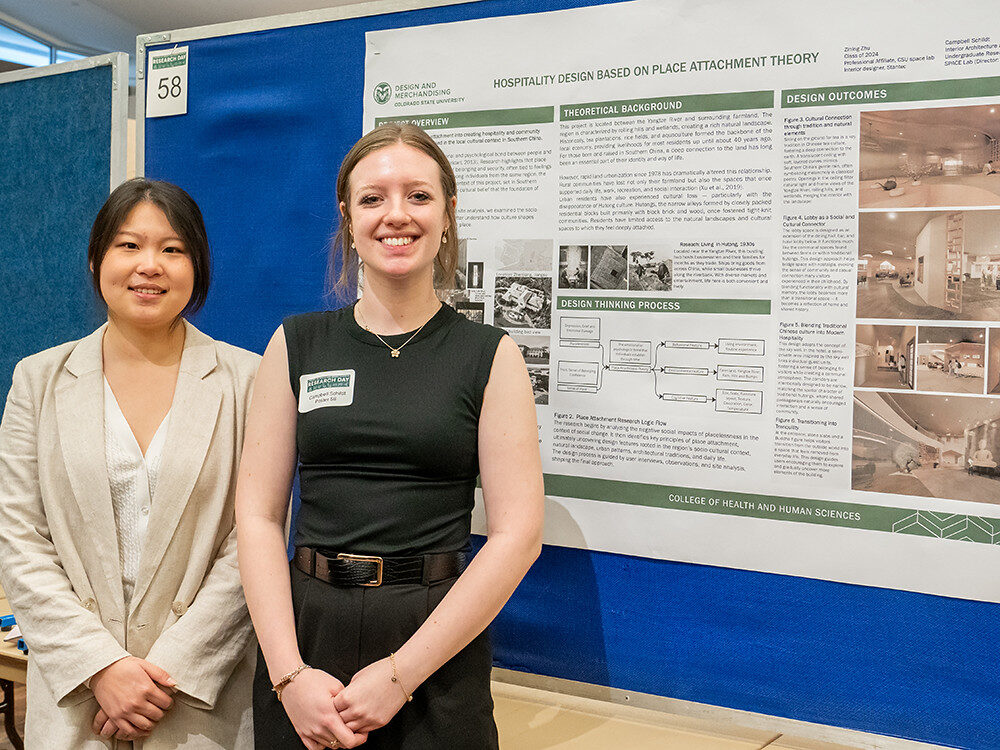 SPACE Lab members Zining Zhu and Campbell Schildt smile while presenting their poster at the 2025 CHHS Research Day