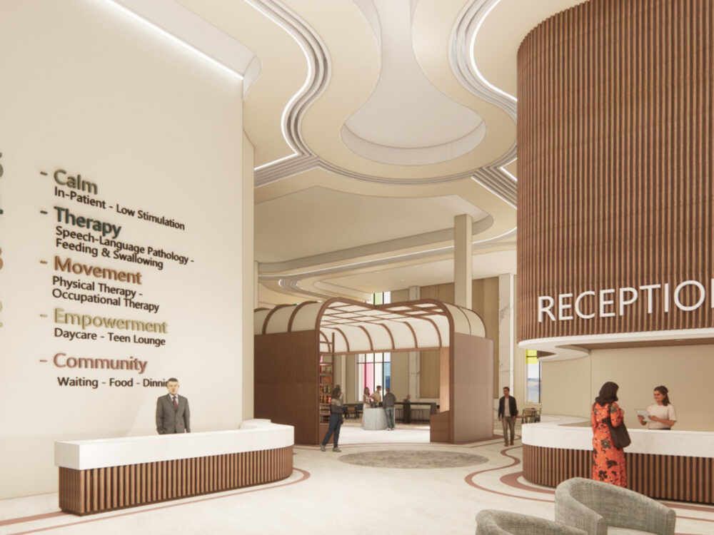 A spacious medical reception area with sculptural ceiling curves, multiple check‑in desks, a large “RECEPTION” sign, and a wall listing care levels from Calm to Community.