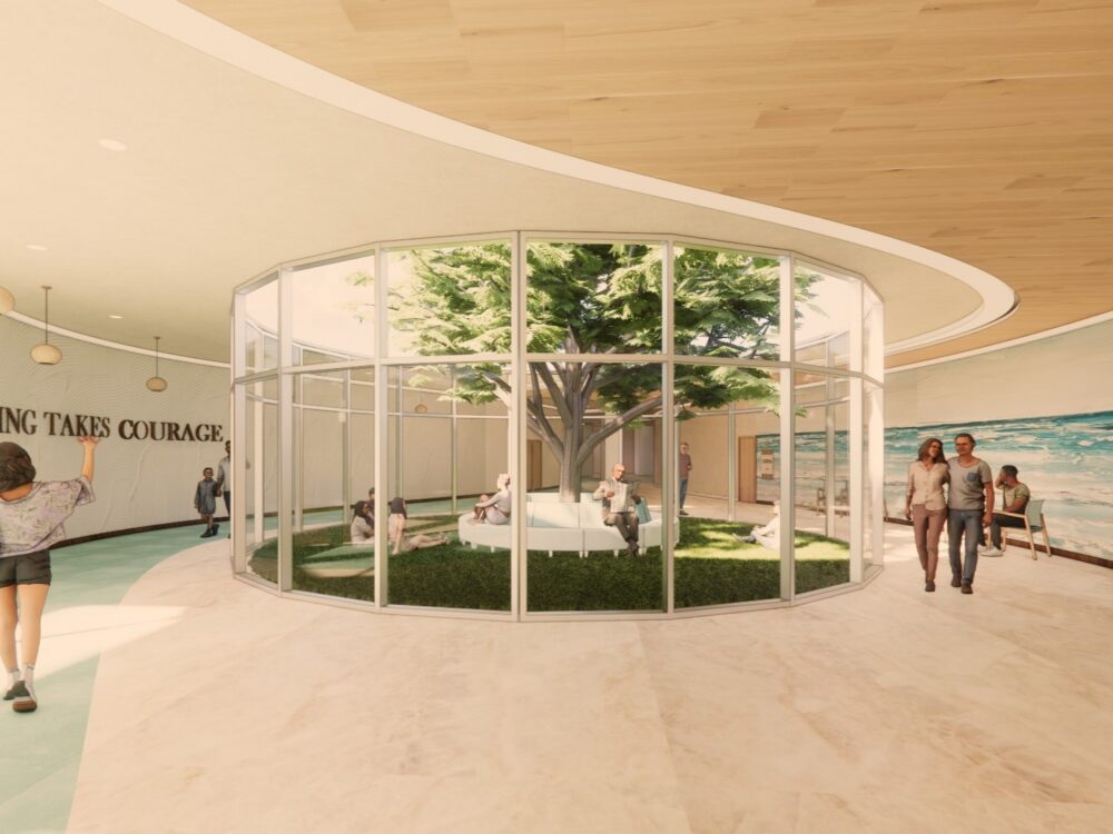 A curved therapy‑center corridor opening into a glass‑enclosed healing garden with seating around a central tree and a mural reading “HEALING TAKES COURAGE.”