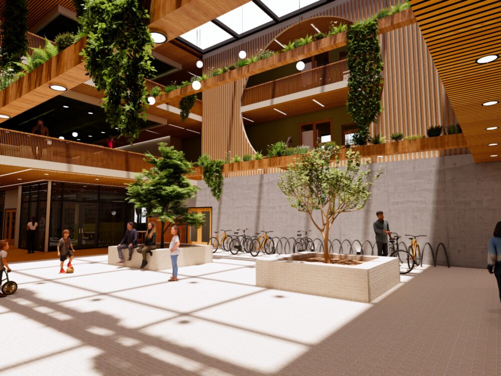 A vibrant community atrium with tall interior trees, bike racks, wood slat balconies, and people gathering beneath skylights and hanging greenery.