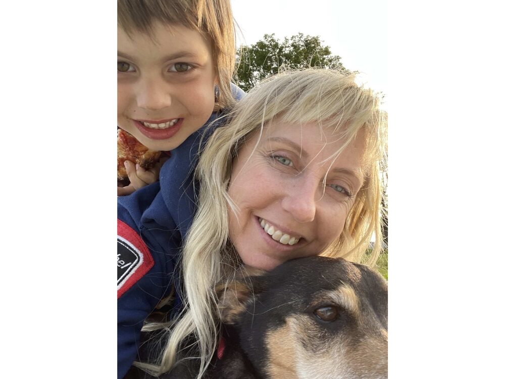 Photo of Lady Soule smiling with her dog and child.