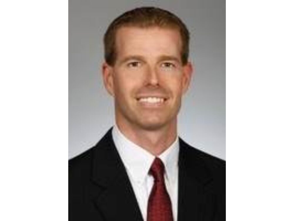 Portrait of Ryan Rodau in front of a gray backdrop