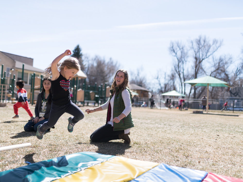 A child jumps on a playmat outdoors at the ECC