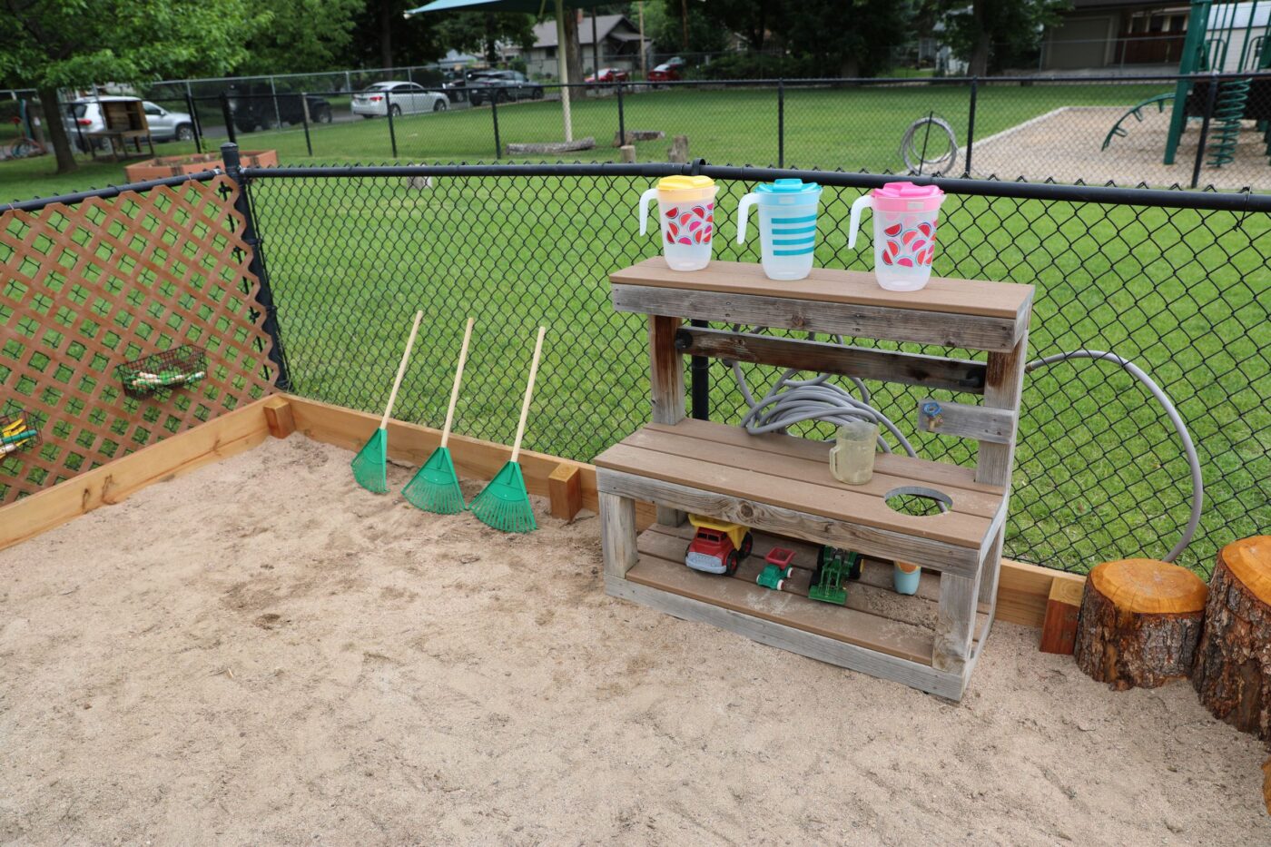 sand pit with rakes and water jugs