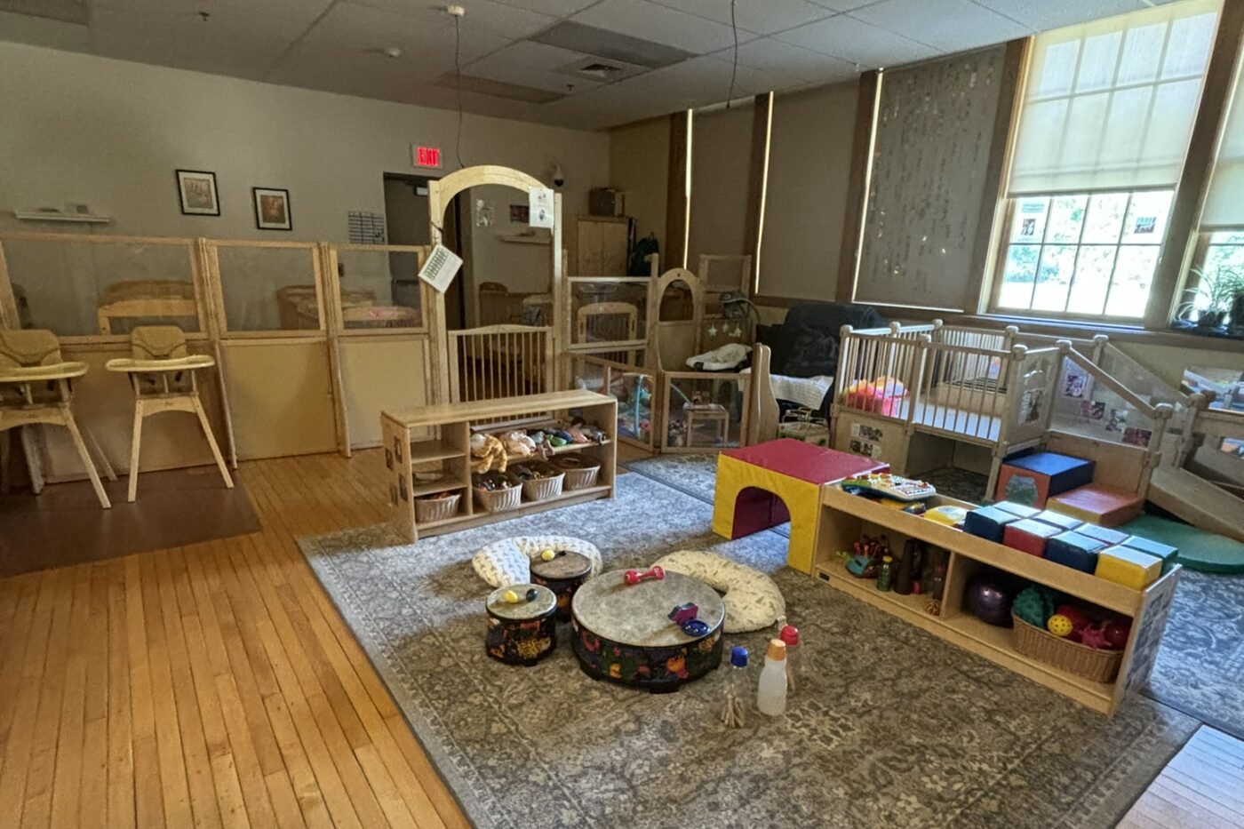Drums on the ground with various toys around a play place for babies