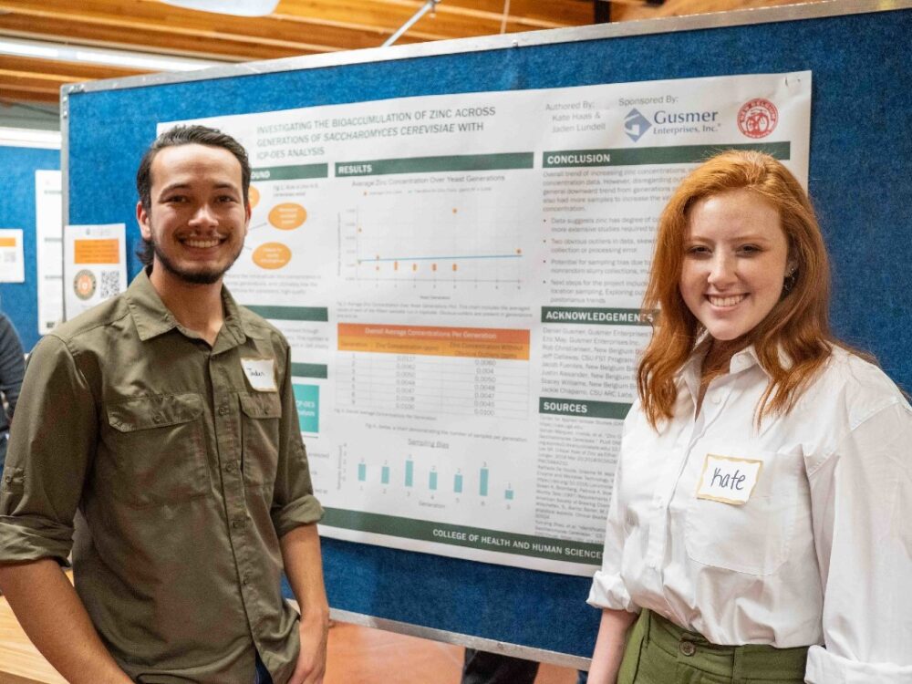 Two students standing in front of a research poster
