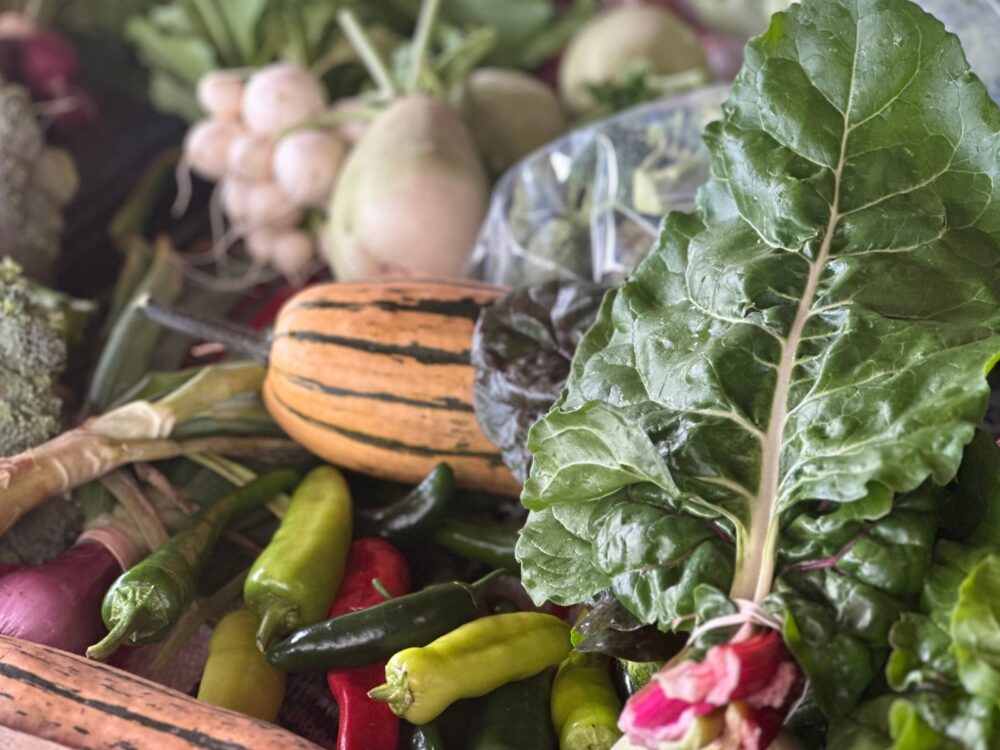 An array of vegetables and peppers on display at a farmers market.