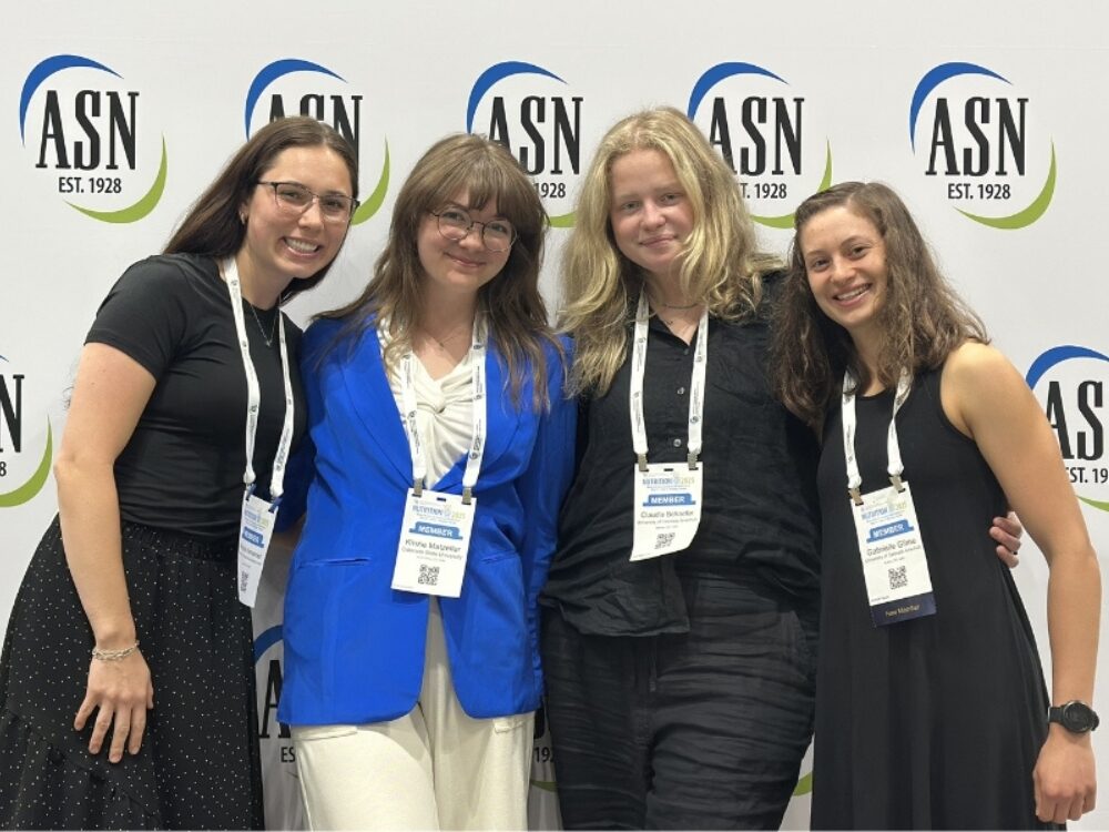 Four members of the PLUS Lab research team smile at the ASN conference.