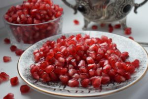 Pomegranate arils in a pile on a white plate