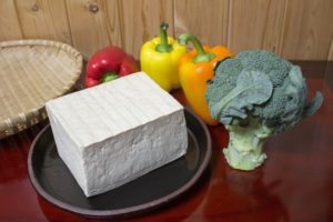A block of tofu surrounded by vegetables