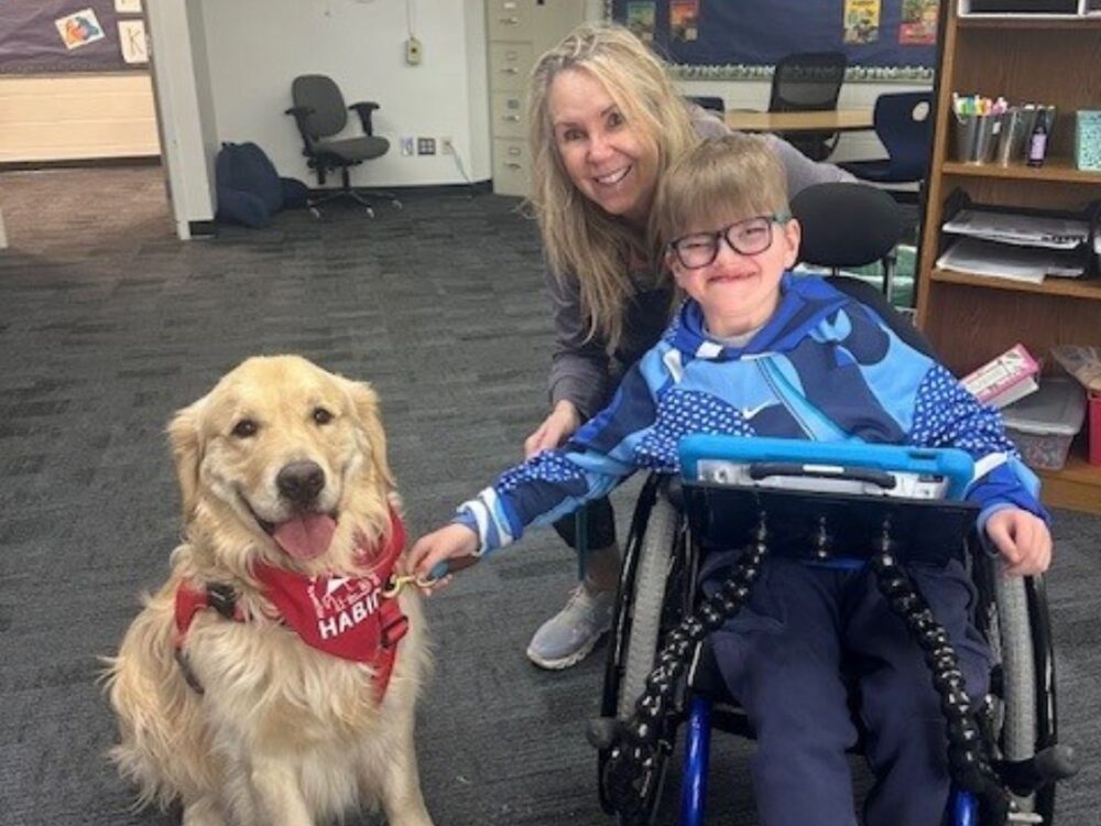 HABIC volunteer with Golden Retriever dog and student