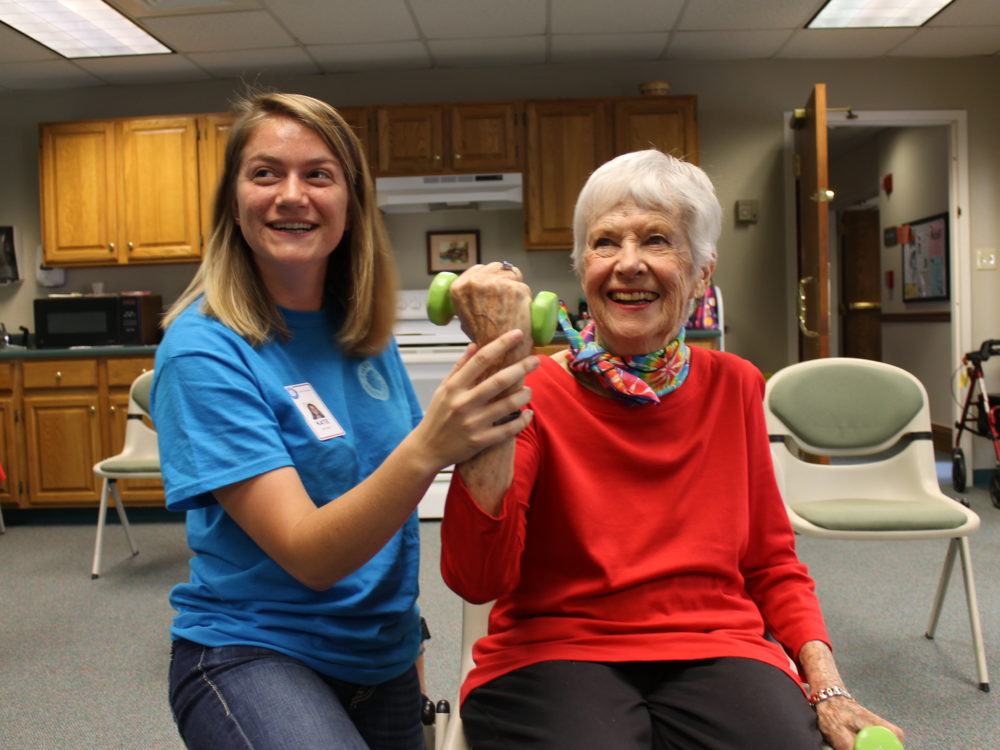 HDFS student works with an older person holding a weight