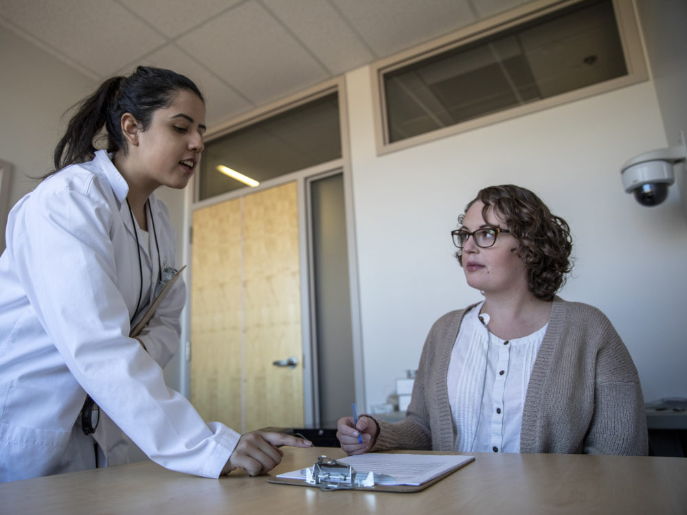 A HEART researcher helps a research participant.