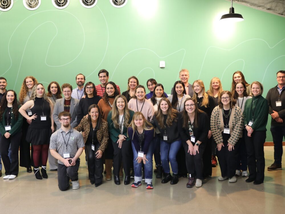 A large group of Developmental Disabilities Research Lab team members smile.