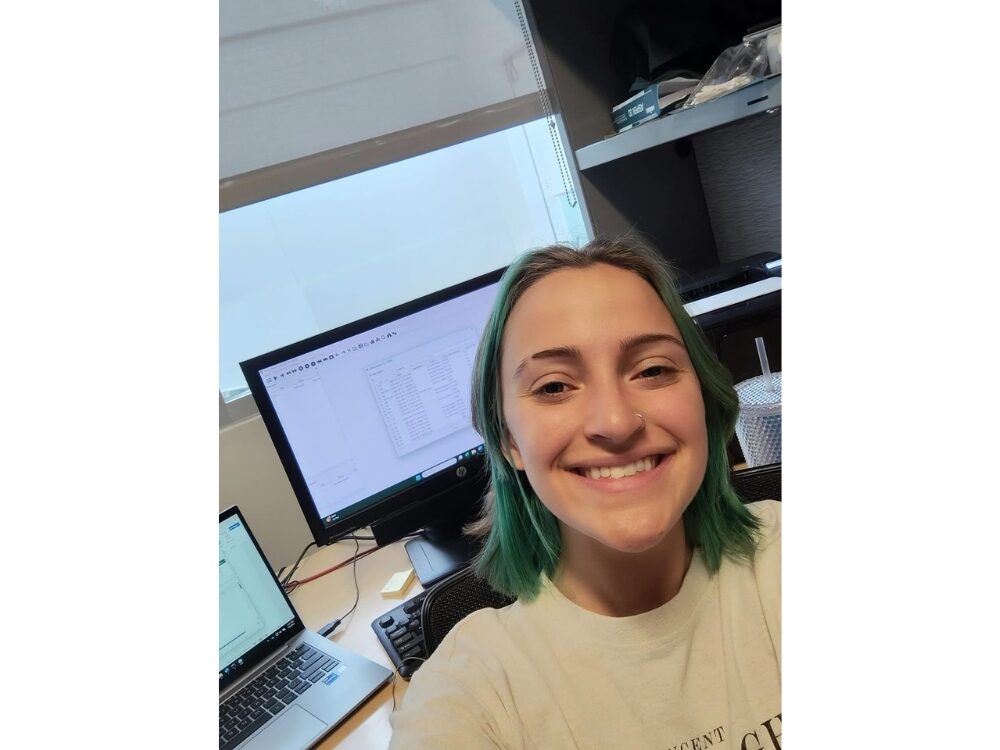 Photo of Human Development and Family Studies student smiling in front of a computer