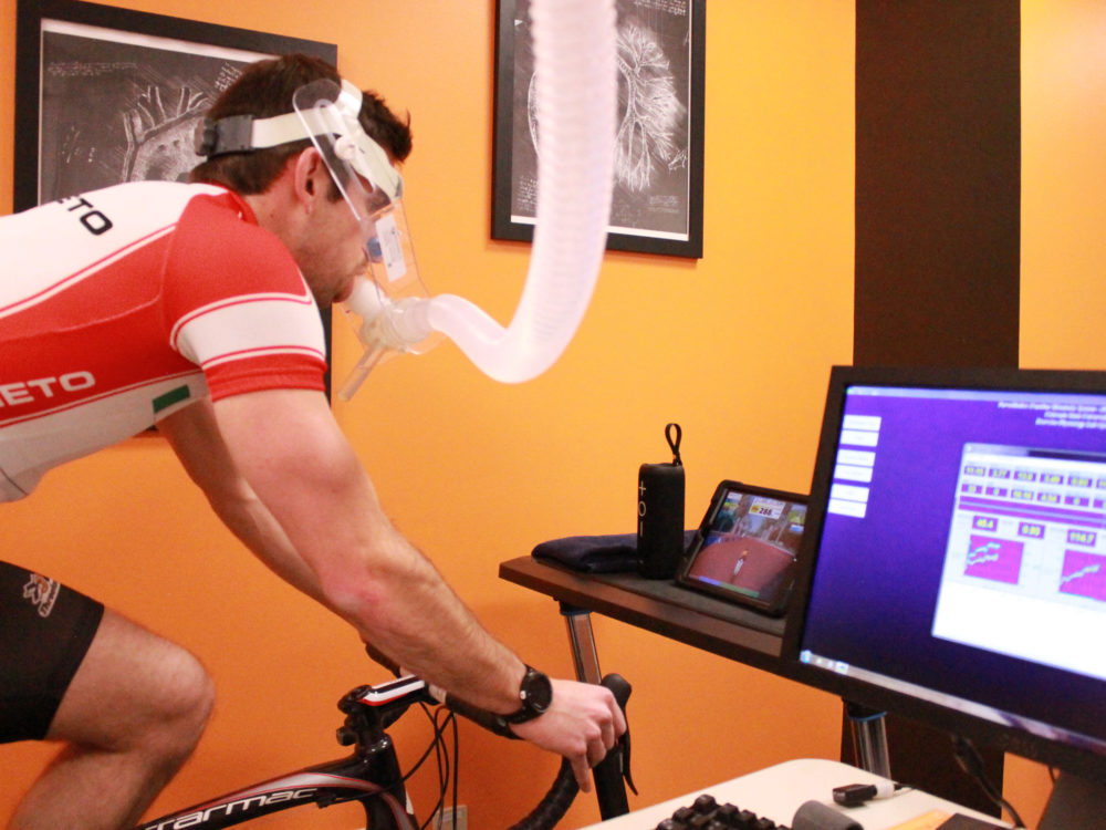 test subject riding a bike while doing a VO2 Max test