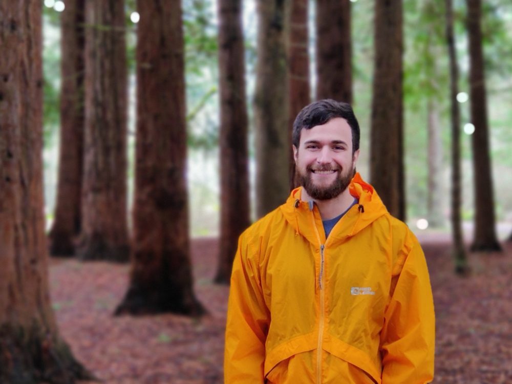 Nick Hulett, ERM Lab Technician, smiling in a forest