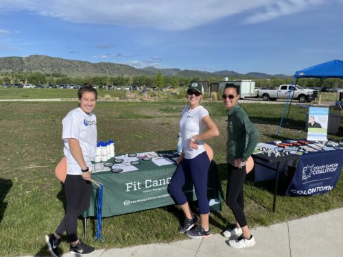 Three PATP lab members stand in front of their table at a community event