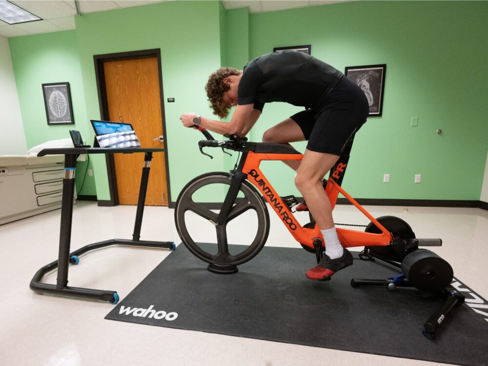 A person rides a stationary bike that is connected to a computer while testing their lactate threshold.