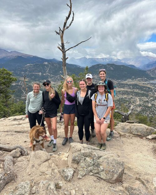 Seven members of the PATP Lab team and a dog smile while outdoors on a hike.