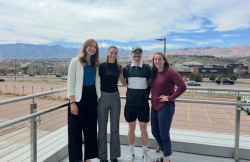 Four members of the PATP Lab team smile outdoors while at a conference.