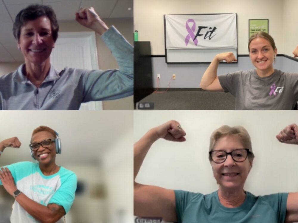 A screenshot of a Zoom call with three Fit Cancer participants and a PATP Lab member smiling while flexing their bicep muscles.
