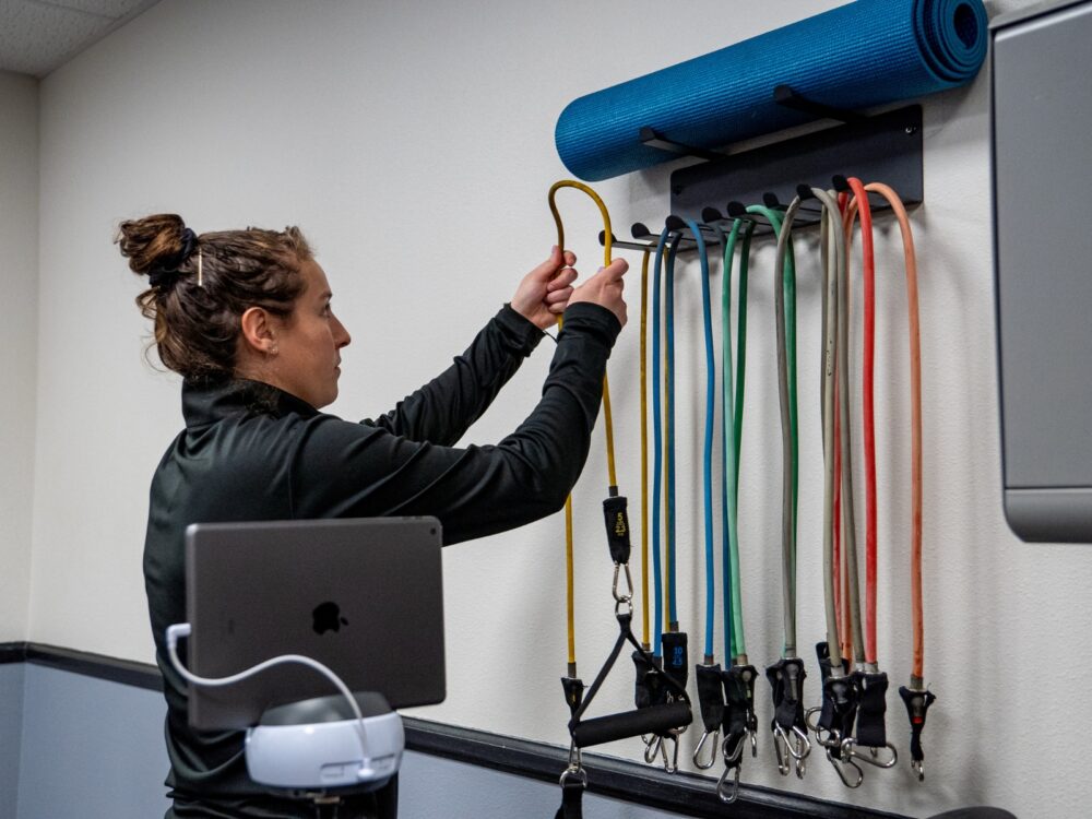 A PATP Lab member organizes workout equipment in the lab space.
