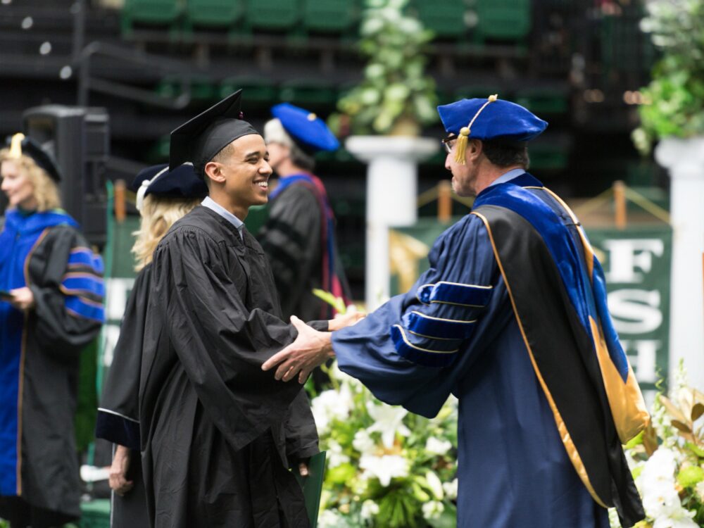 Congratulating a graduate with a handshake