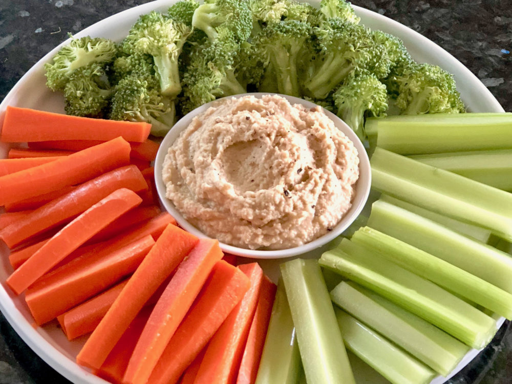 fresh hummus with carrots, celery, and broccoli